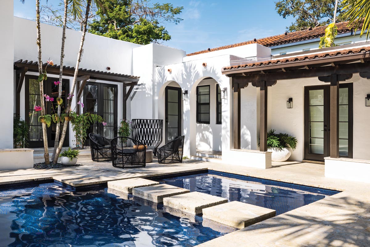 A stone bridge Immersed in the pool waters leads to yet another intimate seating area on the opposite end of the patio. The owners love hosting friends, and their hospitable home speaks to their passion for entertaining.