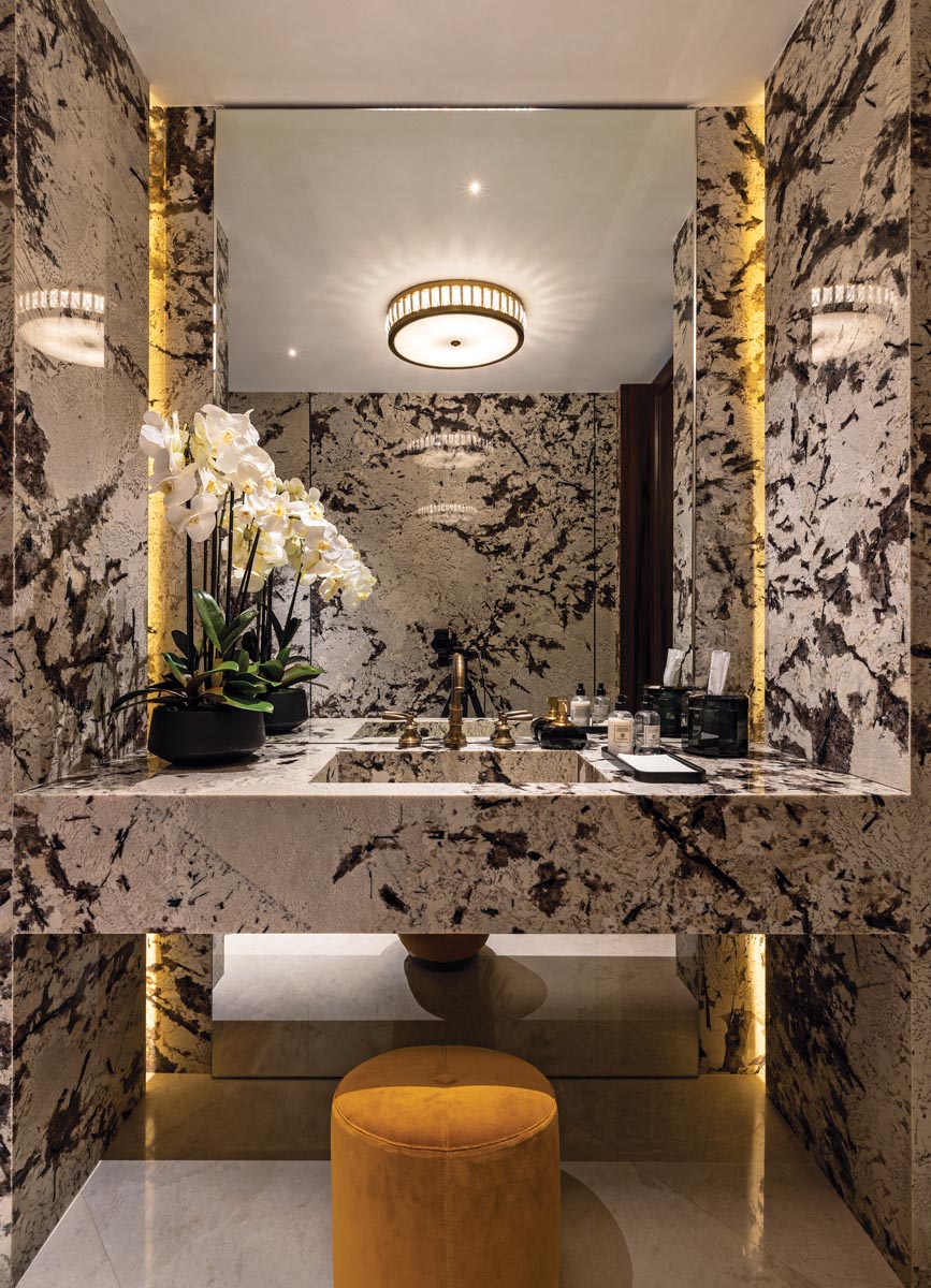 Entirely clad in Bianco Argento marble from Opustone, the powder room is a study in opulence.