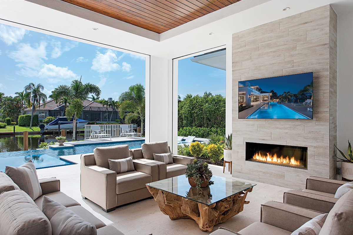 From the pool to the fire pit, custom built-in seating accelerates the art of entertaining. Interactive with the other natural elements, a wall of Tesoro Savannah pressed porcelain planks from Coastal Design stack up seamlessly to shape the fireplace. A sofa and armchairs from Robb & Stucky form a hearthside grouping.