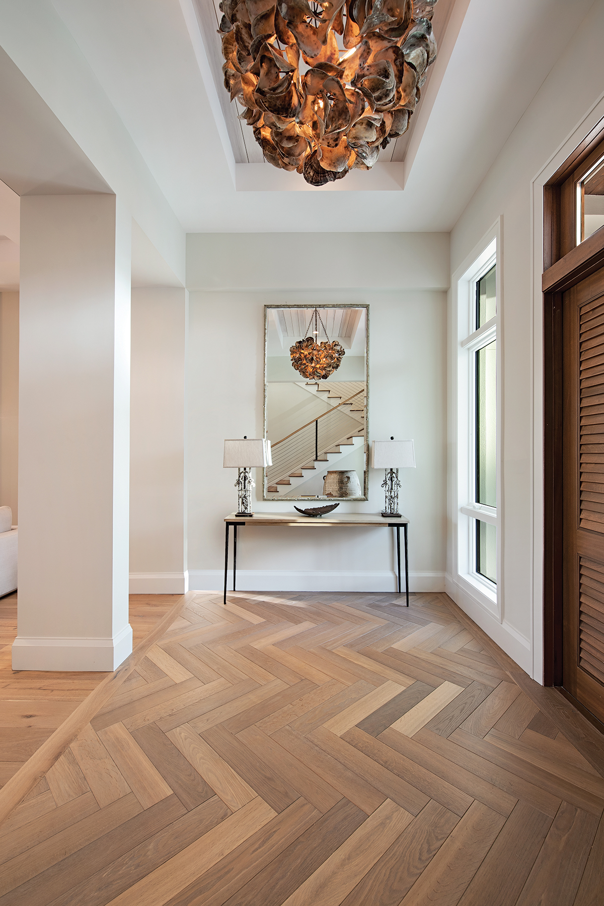 In the foyer, the “Venus” chandelier, a true one-of-a-kind work of art comprised of saddle oyster shells, captivates from above. Legone Bastone’s Giuseppina wood planks from Naples Flooring grounds the entry space in a handsome herringbone pattern.