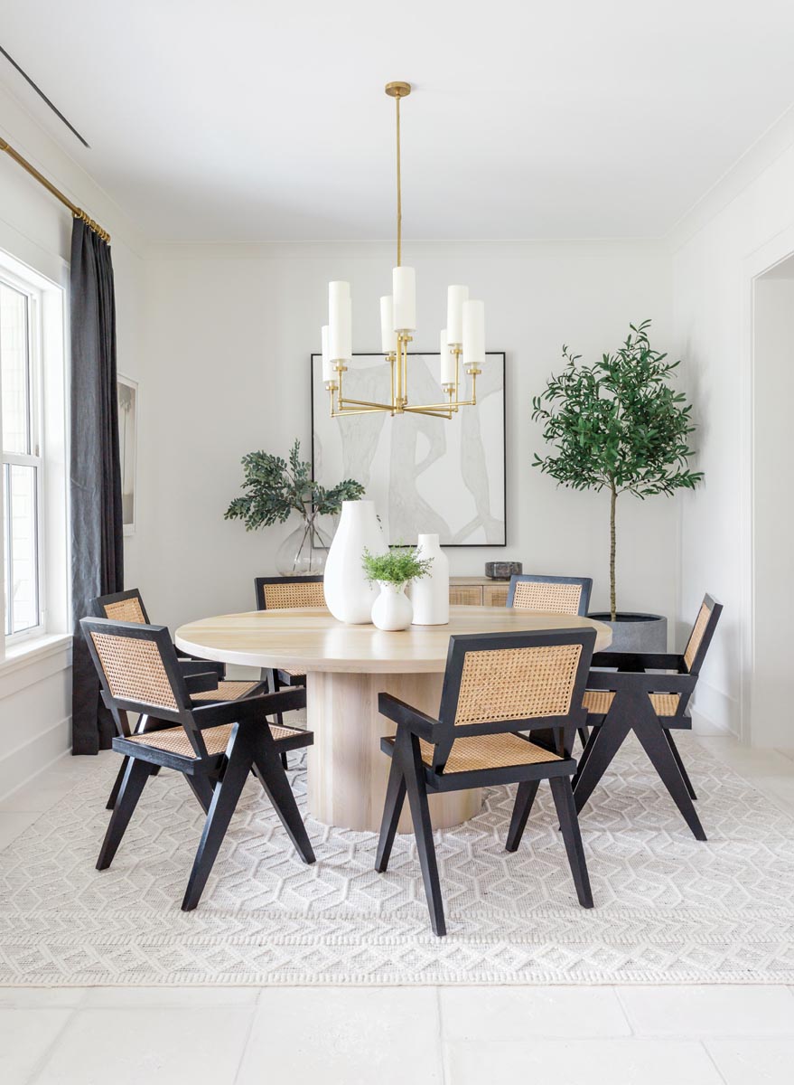 France & Son dining chairs add bold character to break up the lighter tones of the dining room. A chandelier by Visual Comfort gives the space its finishing touch.