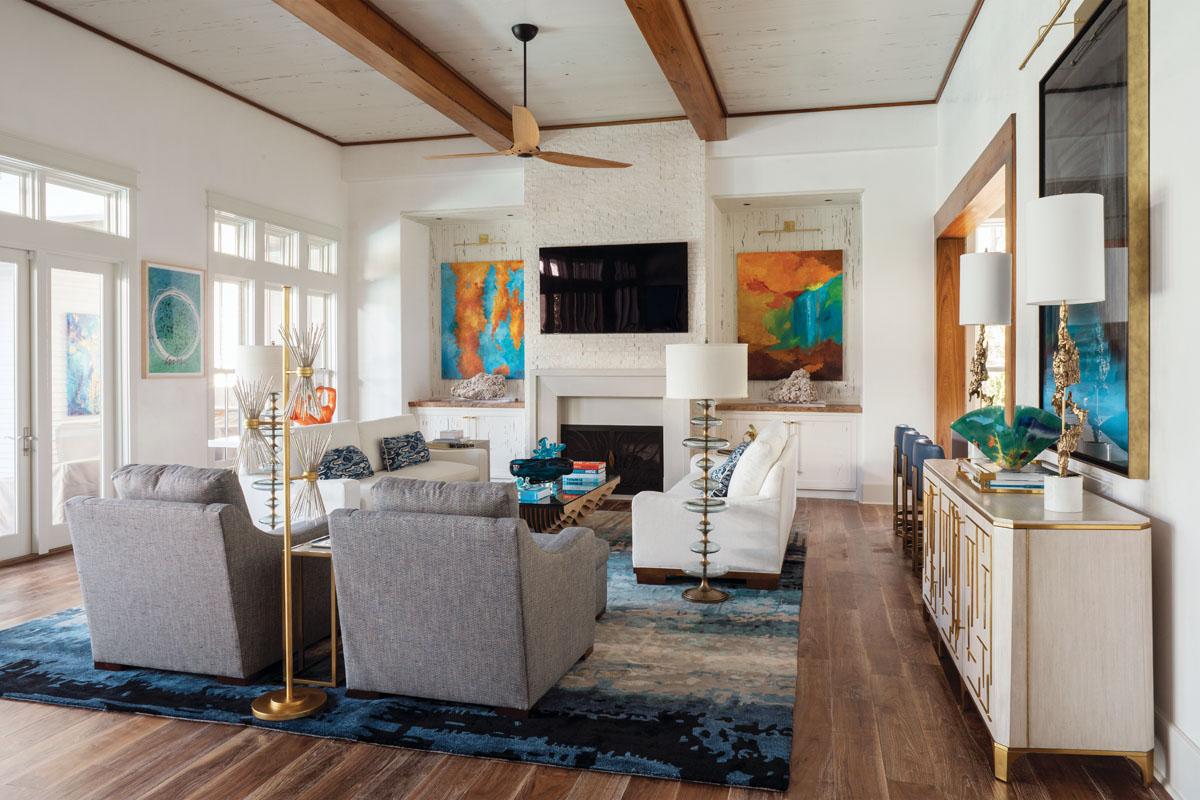 “I was inspired by water and waves,” says interior designer Cara McBroom. “The area rug is full of blue hues that fade in and out like the ocean and provide a strong injection of color. Painted pecky cypress art niches topped with slabs of African teak showcase a vibrant pair of paintings by artist Sandy Hubler.”