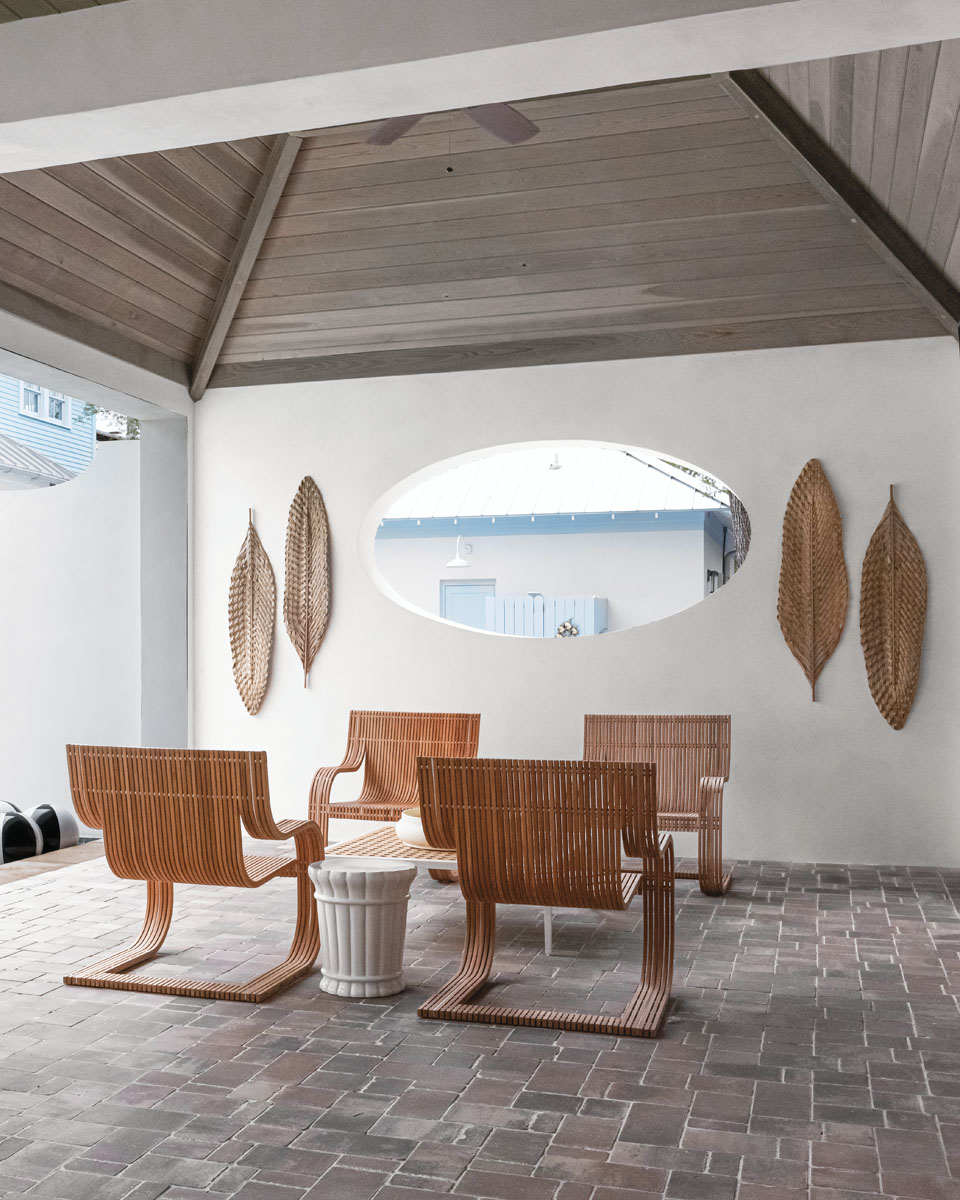 “Formal spaces are out. Intimate spaces are in to extend square footage and give the client options indoors or out,” Savage says. Seeing another opportunity for a poolside lounge area, he created underneath a peaked driftwood ceiling with a Janus et Cie coffee table and David Sutherland teak wood chairs. Dried woven palm fronds add texture to whitewashed walls.