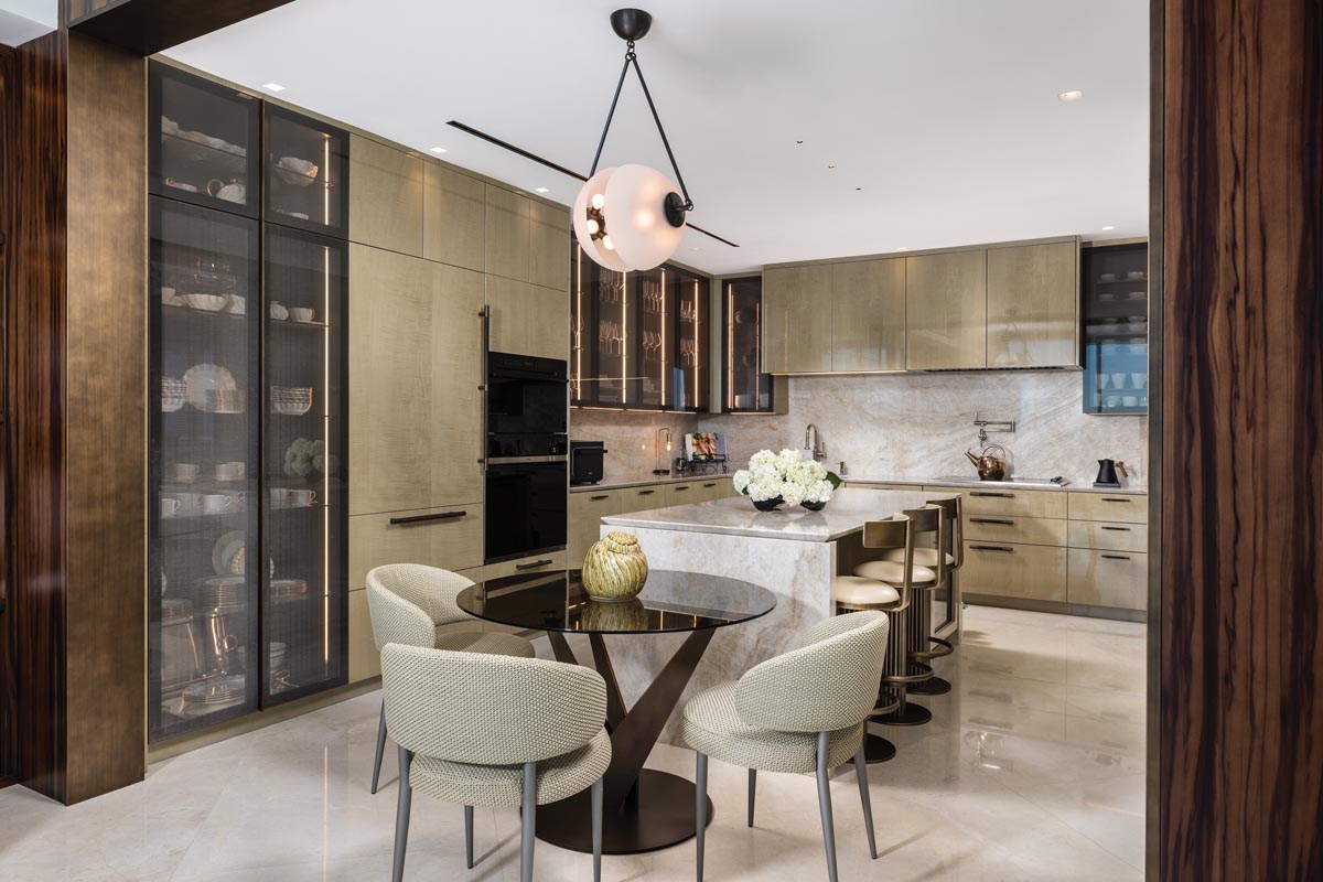 MAS Interior Design designed the kitchen’s cabinetry and island, which are topped with Taj Mahal quartzite. The same stone was used for the backsplash.