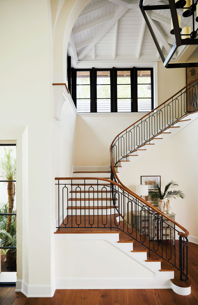 The home’s entry, with a striking wooden staircase designed by Harrison Design and fabricated by Architectural Millwork and Stairs, combines a more traditional vaulted ceiling with a transitional iron railing pattern, crafted by Mudge Metalcraft, and foreshadows the stylistic complexity and marriage of materials that are forthcoming.