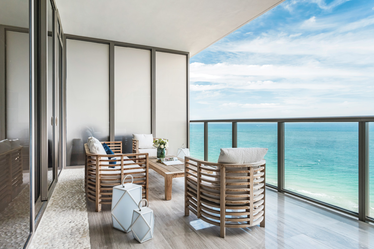 Deep balconies give the residence more visual depth, while also allowing residents to enjoy true indoor/outdoor experiences. The chairs are from Holly Hunt with cushions upholstered in Perennials fabric.