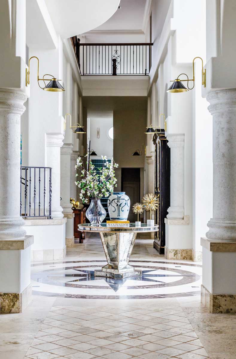 In the tall foyer, the marble inlay floor with its classic compass rose pattern was retained from the original 2005 design of the home by Julie Schulte. The rather formal tone of the foyer does not indicate the design agenda in the rest of the home, which is more reflective of its beach setting.