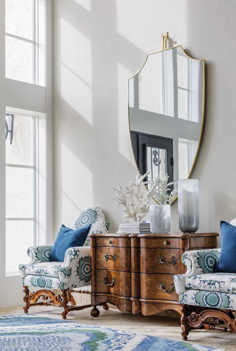 In a seating area in the foyer, an oversized Century mirror brings a modern touch to more traditional furnishings. It is here where the home’s beachside locale begins to reveal itself with nods to blue shades and sea life.