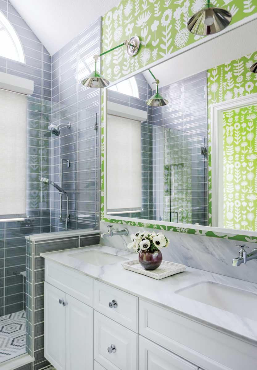 A lively Schumacher wallpaper with green floral motifs delights the eye in the bunk room’s bathroom.