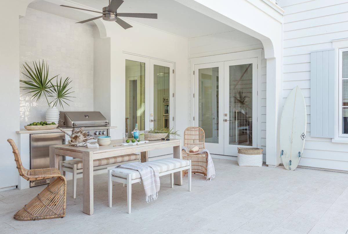 Zellige tile in various shades of white unites with stucco walls and vintage furnishings to provide natural textures in the outdoor dining room.
