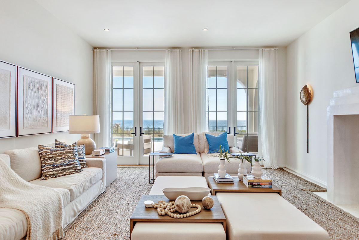 Neutral shades dominate the aesthetic of the family room, while pops of blue blend with the seascape outside.