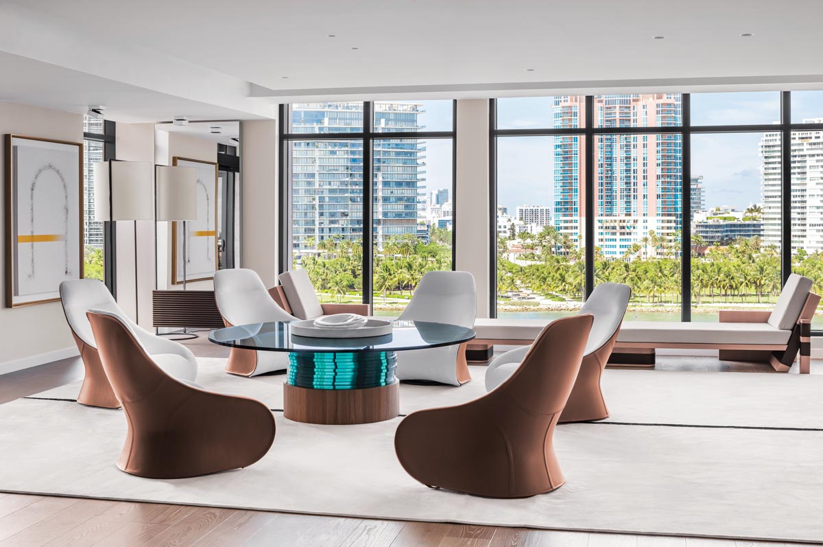 Nestled into a prime corner spot in the living area, a lounge space for wine tasting offers guests a spectacular view of the water. Sinuous Zanotta Derby chairs complement a round glass-topped Mizu table by Poggi Design. Custom 16-foot chaise lounges line the back windows.
