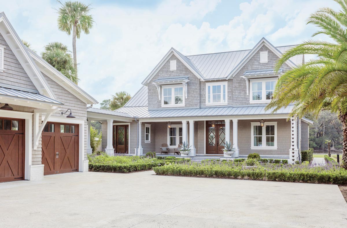 Interior designer Lauren Leonard came onto the project when the house was framed, so she helped the clients pick the exterior finishes. The color of the shingle-style home was inspired by a sun-washed piece of wood. White trim and warm outdoor lighting complete the coastal look.